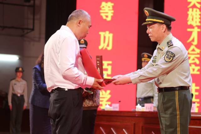 汪曉龍家屬接過一等功獎章及獎勵證書